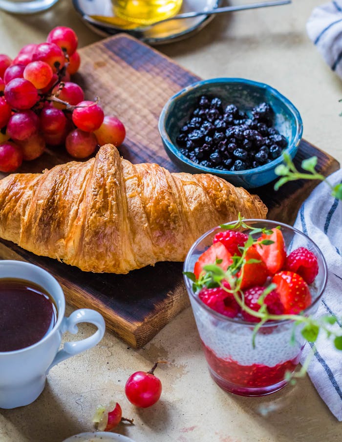 how-it-works Vibrant breakfast setup featuring a croissant, fresh fruit, and coffee.