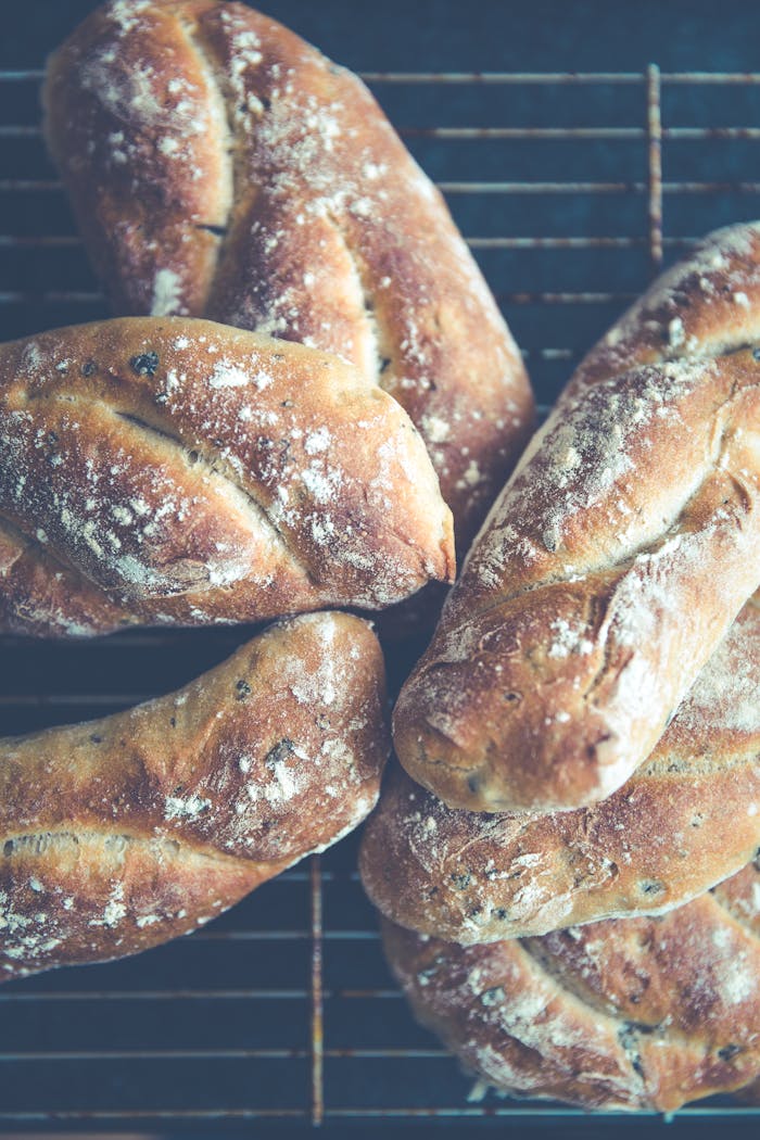 services-04 Close-up of artisanal loaves of bread cooling on a wire rack highlighting rustic texture.